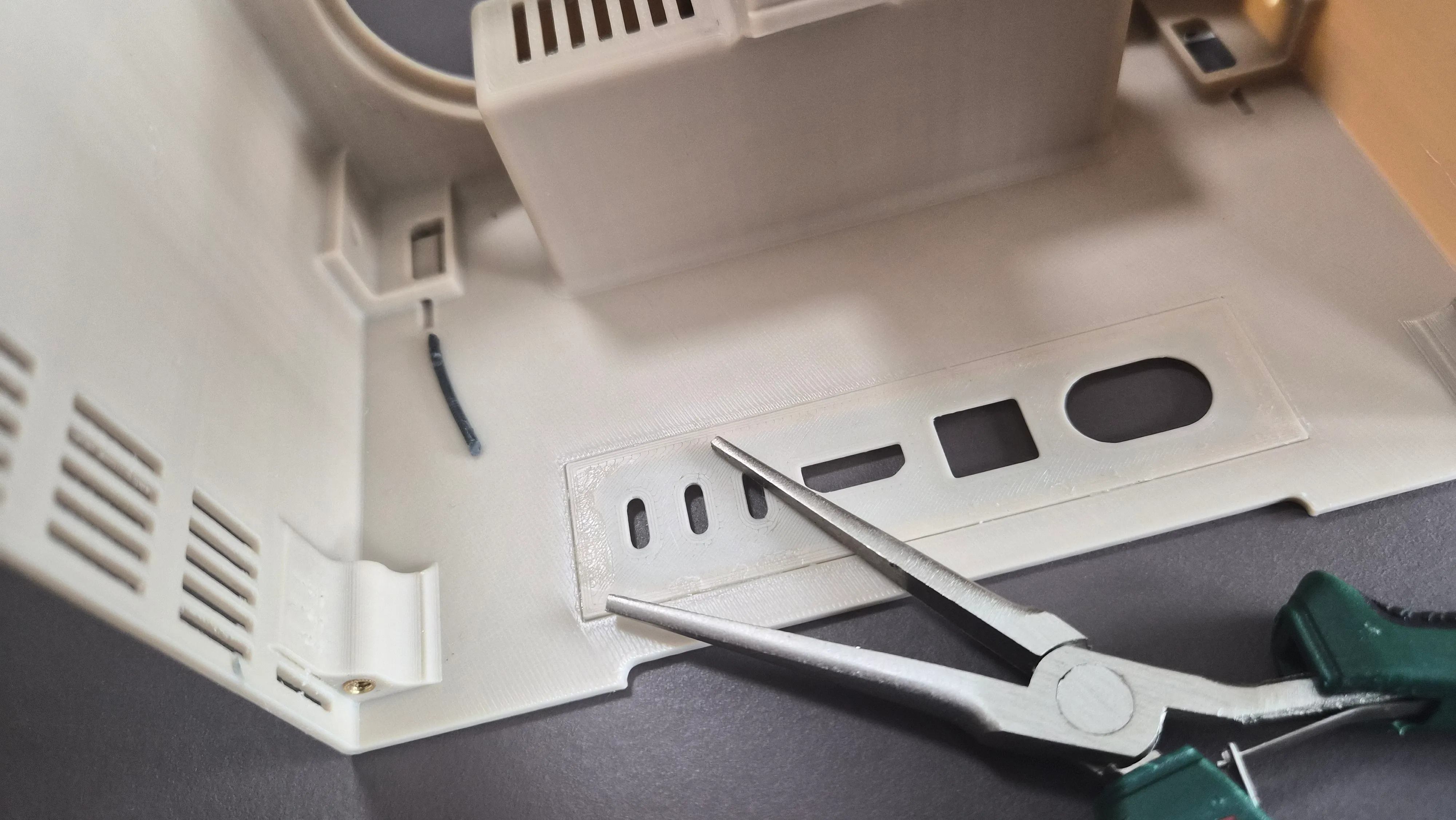 Use a bit of glue to attach the cover for the I/O on the back of the main body.